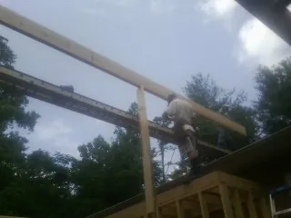 Carpenter setting a ridge beam over a new addition frame — Ice Dam Removal by Roofing Brothers in Eden Valley
